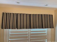 Front view of entire striped cornice mounted above shutters