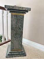 Full view of granite pedestal showing height, brass accent band, stepped base and cap