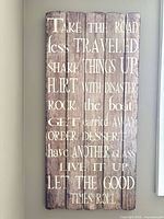 Full view of vertical wood sign showing text and plank construction