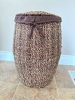 Front view of woven seagrass laundry hamper with lid