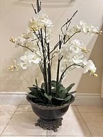 Full view of white silk orchid arrangement in urn planter