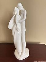 Front view of white porcelain wedding couple figurine on wood surface