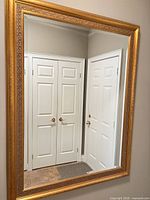 Full view of mirror on wall showing rectangular shape and gold frame