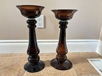 Front view of both amber glass candle holders showing full height difference and design
