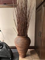 Full view of wicker floor vase with twig branches