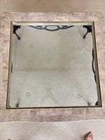 Top view showing square marble frame with glass inset and iron base visible