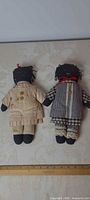 Front view of both dolls side by side with ruler indicating height