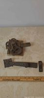 Overall view of latch mechanism, strap handle and strike plate with ruler for scale