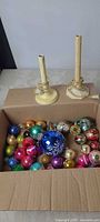 Box showing two wooden electric candle lights and assorted ornaments