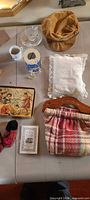 Overview showing cap, dish, mug, toy drum, pillow, purse, slippers, puzzle, booklet