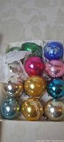 Assorted multicolour glass ball ornaments in open box