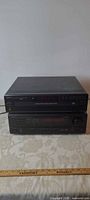 Two Denon components stacked: top DCM-370 CD changer, bottom AVR-1601 receiver