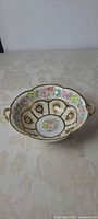 Top view showing floral panels, gold medallions, twin handles