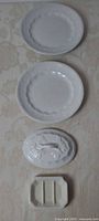 Top-down view of two plates, one lid and one soap dish