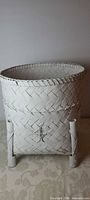 front view of white woven basket on stand