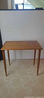 Full front view of teak side table showing overall form