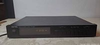 Front view showing Rotel branding, model number, display lit to 87.5 MHz, control buttons and power switch