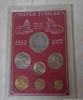 Front view of the 7-coin Silver Jubilee set in red display case