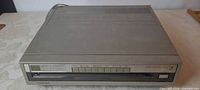 Front view of Toshiba stereo video disc player showing slot, controls and display