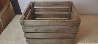 Front angled view of weathered wooden slatted crate