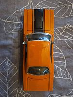 Top view of orange Plymouth GTX model showing hood stripes and roof