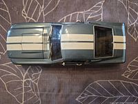 Top view showing metallic blue body, white stripes, scuffed windows