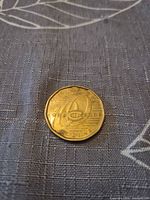 Obverse and reverse views of the 2009 Canadian $1 brass coin on fabric surface