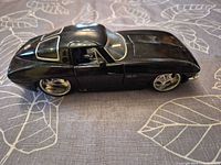 Left side view of the black 1:24 1963 Corvette model showing chrome wheels and wear on body