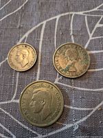 Obverse of three coins showing portraits and dates