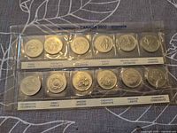 Obverse view of 12 commemorative quarters in sealed sleeve