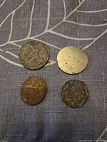 Four coins front view on fabric backdrop