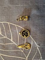 Front view showing three gold-tone pendants/charm