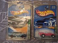 Front view of both Hot Wheels blister packs showing Ford Mustang and red convertible