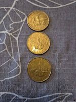 All three coins front side visible: 2008 Olympic loon reverse on top, two 1992 Parliament reverses below