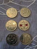 Six coin reverses showing commemorative designs including poppy, hockey, bird, sailboat