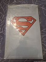 Front of sealed polybag showing red Superman shield logo