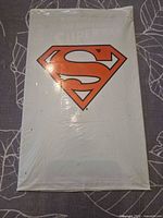 Front of sealed polybag with Superman shield logo