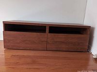 Front view of wood console showing two shelves and two drawers closed