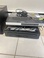 Akai turntable stacked on Genorra CD player, cabling visible