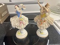 Front view of both Dresden lace figurines on stove surface