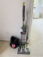 Full view of Hoover upright vacuum and accessory bag nearby