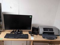 Wide shot showing monitor, keyboard, printer, external device