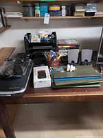 Overview of desk with scanner, speakers, folders, letter tray and office supplies