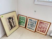 All four framed artworks leaning against wall