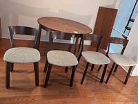 Four wooden dining chairs in front of round table