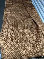Full view of folded silk coverlet showing color and pattern