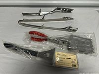 All four barbecue utensils laid out, showing overall condition and type