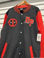 Front view of black and red Deadpool varsity jacket showing chest logos, snap buttons, pockets and hang tag