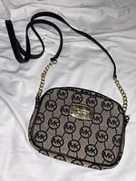 Front view of Michael Kors Jet Set monogram crossbody bag showing logo plaque and strap