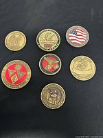 Seven coins including U.S. Navy, Washington SWAT, Operation Iraqi Freedom, Marine Corps and others on black background